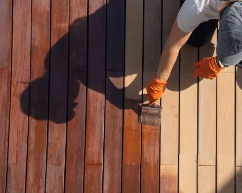 Timber oil being brushed onto decking boards